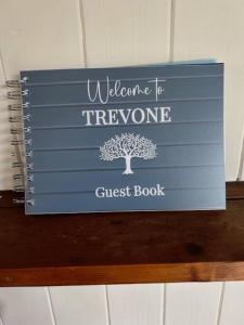a sign for a welcome treephrine guest book at Bright and sunny village home in Ipplepen
