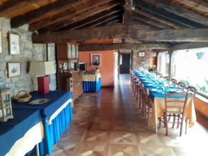 ein langes Esszimmer mit blauen Tischen und Stühlen in der Unterkunft La Casona de Barrio in Barrio