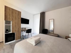 a hotel room with a bed and a tv and a room at Pinea b&b in Castellaneta Marina 