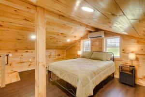 ein Schlafzimmer in einem Blockhaus mit einem Bett in der Unterkunft Friends and Family Rental Cabin with Hot Tub! 