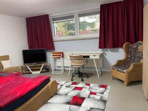 Schlafzimmer mit einem Bett und einem Schreibtisch mit einem TV in der Unterkunft Haus der 5 Elemente mit Gemeinschaftsbad in Göttingen