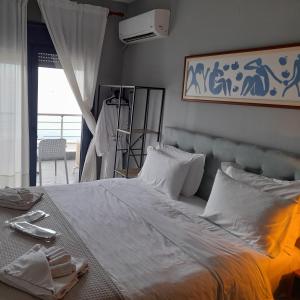 1 dormitorio con 1 cama blanca grande con almohadas blancas en Cabo Verde, en Agia Triada