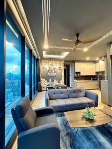 a living room with blue couches and a kitchen at Suite Opus Kuala Lumpur in Kuala Lumpur