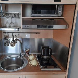 a small kitchen with a sink and a microwave at Cabo Verde in Agia Triada