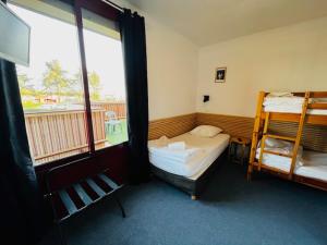 a room with two bunk beds and a window at HOSTEL Les Bois Verts - Les Herbiers in Les Herbiers