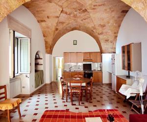 una cucina e una sala da pranzo con tavolo e sedie di Casa Ottavio a Tiggiano
