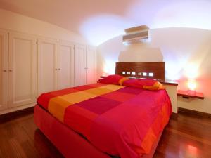 羅馬的住宿－鬥獸場甜蜜之家公寓，一间卧室,卧室里配有一张色彩缤纷的床