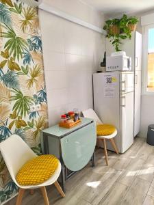 a kitchen with a table and two chairs and a refrigerator at Madrid Centro in Madrid