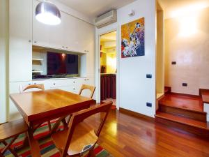 Il comprend une cuisine et une salle à manger avec une table en bois. dans l'établissement Sweet Home Colosseo, à Rome