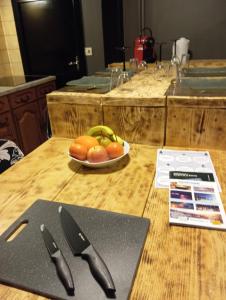 een snijplank met een mes en een kom fruit bij Chez Ana à Morez in Morbier