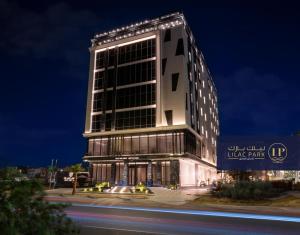 um edifício alto com luzes acesas à noite em Lilac Park Hotel em Tabuk