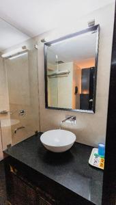 a bathroom with a sink and a mirror on a counter at Garden Hotel Panvel in Navi Mumbai