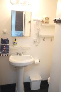 a white bathroom with a sink and a mirror at Midtown Nest Studio Self Serviced Apartment Sleeps 5 in New York
