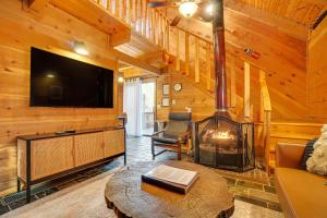 ein Wohnzimmer mit einem Kamin und einem Flachbild-TV in der Unterkunft Sautee Nacoochee Mtn Paradise with Spacious Deck! in Sautee Nacoochee