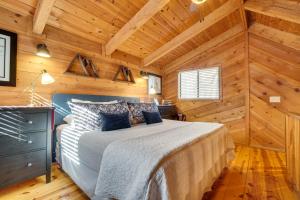 um quarto com uma cama num chalé de madeira em Sautee Nacoochee Mtn Paradise with Spacious Deck! em Sautee Nacoochee