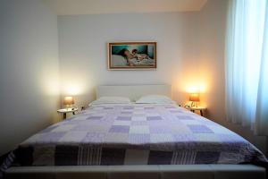 a bedroom with a bed with a blue and white quilt at Apartman Nada I in Fažana