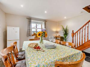 2 Bed in Bude 51764 في Pyworthy: طاولة غرفة الطعام مع إناء من الزهور عليها