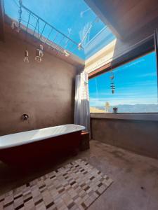 a large bathroom with a tub and a large window at Cabana Monte - Pousada Colina dos Ventos in Urubici