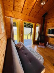 eine Couch in einem Wohnzimmer in einer Hütte in der Unterkunft Cabana Monte - Pousada Colina dos Ventos in Urubici