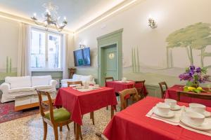 jadalnia z dwoma stołami z czerwonymi obrusami w obiekcie Villa Tortorelli we Florencji