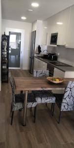 une cuisine avec une table en bois et quelques chaises dans l'établissement Appartement Penthouse Orihuela costa, à Orihuela Costa