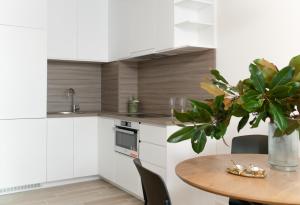 a kitchen with a table and a vase with a plant at Cozy Home in Bečići