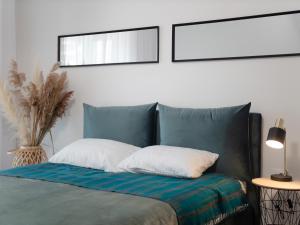 a bed with two pillows and a mirror above it at Cozy Home in Bečići +32 photos