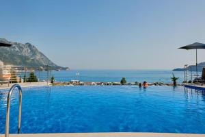 a swimming pool with a view of the ocean at Cozy Home in Bečići