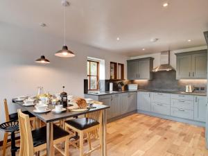a kitchen with a table and chairs and a kitchen with blue cabinets at 3 Bed in York 37254 in Fangfoss