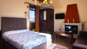 una camera con letto, scrivania e camino di villa Morfeas a Dhamavólos