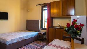 mały pokój z łóżkiem i wazą kwiatów w obiekcie villa Morfeas w mieście Dhamavólos