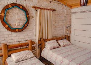 a bedroom with two beds and a clock on the wall at Paradise Camp in Monte das Gameleiras +97 photos