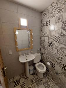 ein Badezimmer mit einem Waschbecken, einem WC und einem Spiegel in der Unterkunft MELMAR - Habitación triple con baño privado in Godoy Cruz