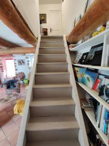 Una escalera que conduce a una habitación con libros en Maison d'Hôtes à Saint Nectaire Chez MamBillig, en Saint-Nectaire