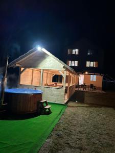 ein kleines Haus mit Badewanne im Hof nachts in der Unterkunft Popasul Drumețului Transfăgărășan in Curtea de Argeş