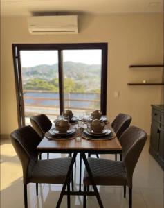 einen Esstisch mit Stühlen, einem Tisch und einem Fenster in der Unterkunft Condominio en Residencial privada in Santa Rosa de Copán