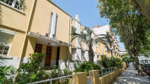 un edificio en una calle con palmeras y una valla en Oporto Yellow Villas en Oporto