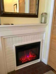 a fireplace with a red fire in it at Cozy studio near DC (in walkable Falls Church, VA) in Falls Church