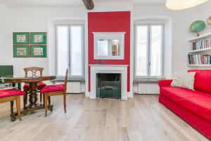 sala de estar con pared roja y sofá rojo en Charming and elegant apartment historic center of Milan, en Milán
