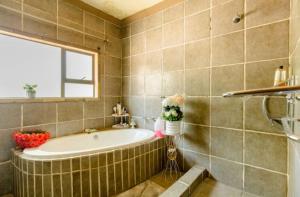 a bathroom with a tub and a window at iShoba Retreat in Centurion