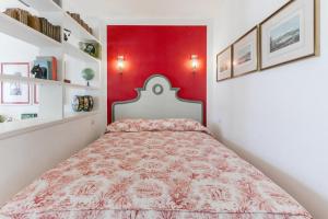 Charming and elegant apartment historic center of Milan في ميلانو: غرفة نوم بسرير بجدار احمر