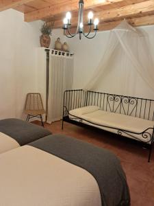 a bedroom with two beds and a chandelier at Ruta del Agua Casa Completa 4 hab al lado Monasterio de Piedra in Munébrega