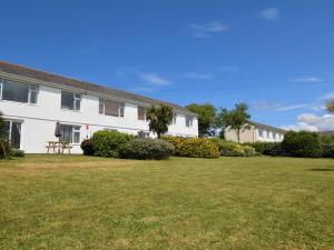 a white building with a grass yard at 2 Bed in Bude 53635 in Bude