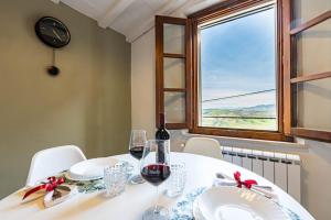- une table avec des verres de vin et une fenêtre dans l'établissement La Kasetta, à Terricciola