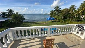 - un balcon blanc avec vue sur l'océan dans l'établissement Emerald Luxe Suites, à Îles du Maïs