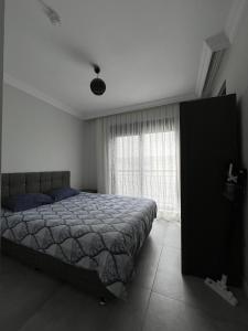a bedroom with a bed and a large window at A flat with two rooms close the Lara Beaches d12 in Altınkum