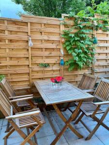 una mesa con 4 sillas y una valla en Appartement 65m2 avec terrasse privé & jacuzzi, en Vaulx-en-Velin