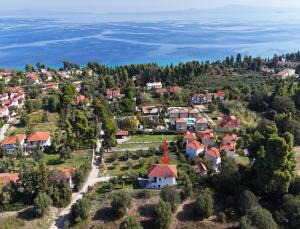 an aerial view of a small village with houses and the ocean at Scenic Kriopigi Getaway - Cozy Anna-Maria Apartment for 4 in Kriopigi