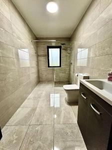 uma casa de banho com um lavatório, um WC e uma janela. em Portmagee Paradise em Portmagee