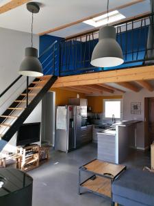 eine Küche mit einer Treppe und ein Wohnzimmer in der Unterkunft Gîte Ludomi in Vercheny